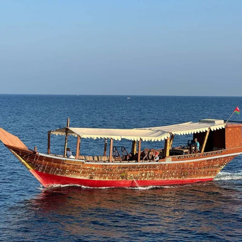 A traditional wooden dhow on calm blue water