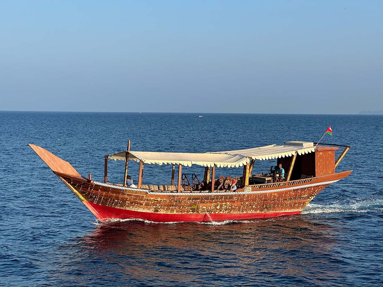 A traditional wooden dhow on calm blue water