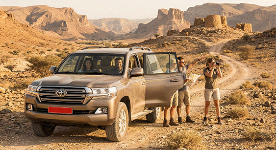 Travellers beside their 4x4 on a mountain track