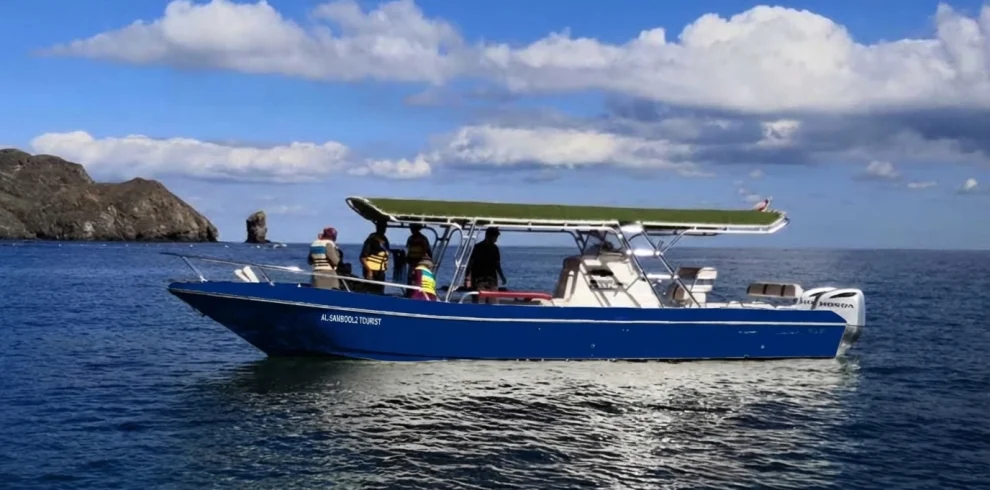 A fishing boat with anglers off a rocky coast