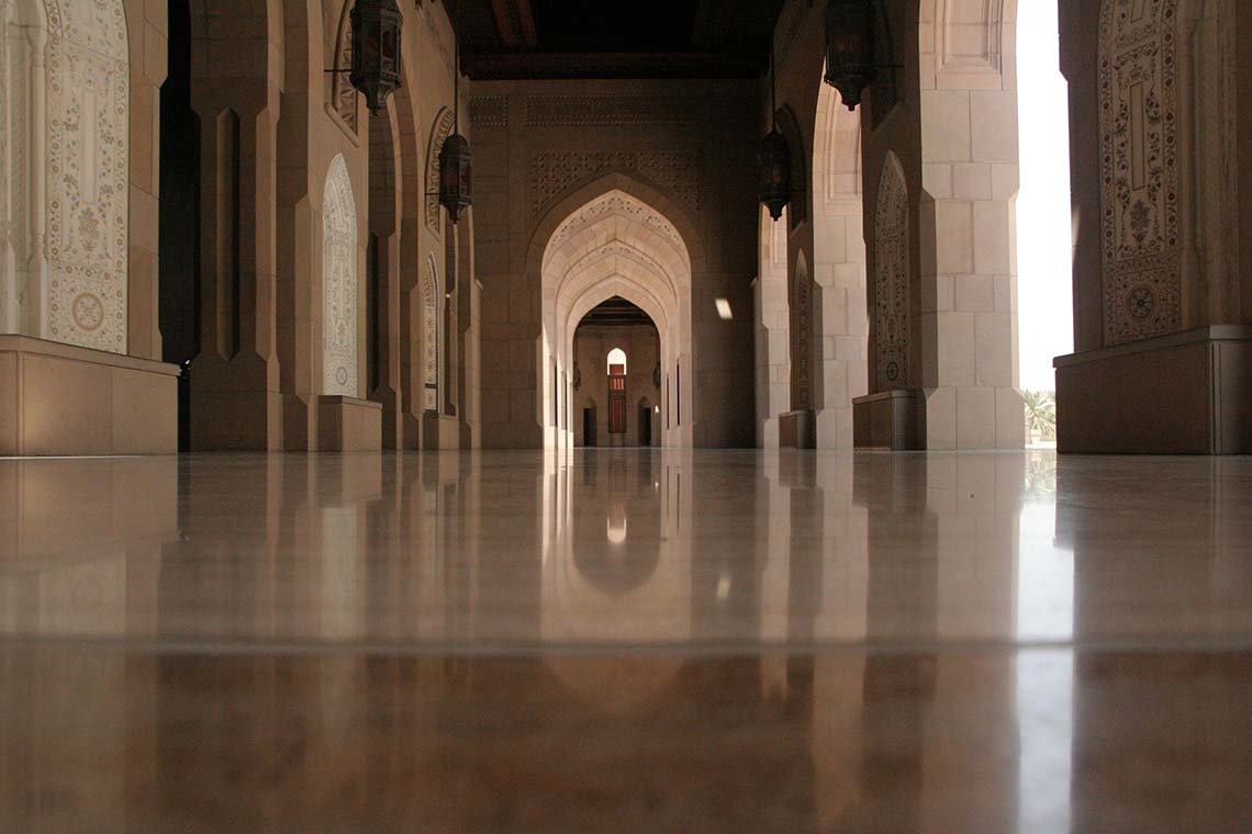 Arched corridor with a polished floor at the Sultan Qaboos Grand Mosque