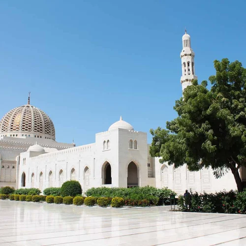 The Sultan Qaboos Grand Mosque with its dome and minaret behind gardens