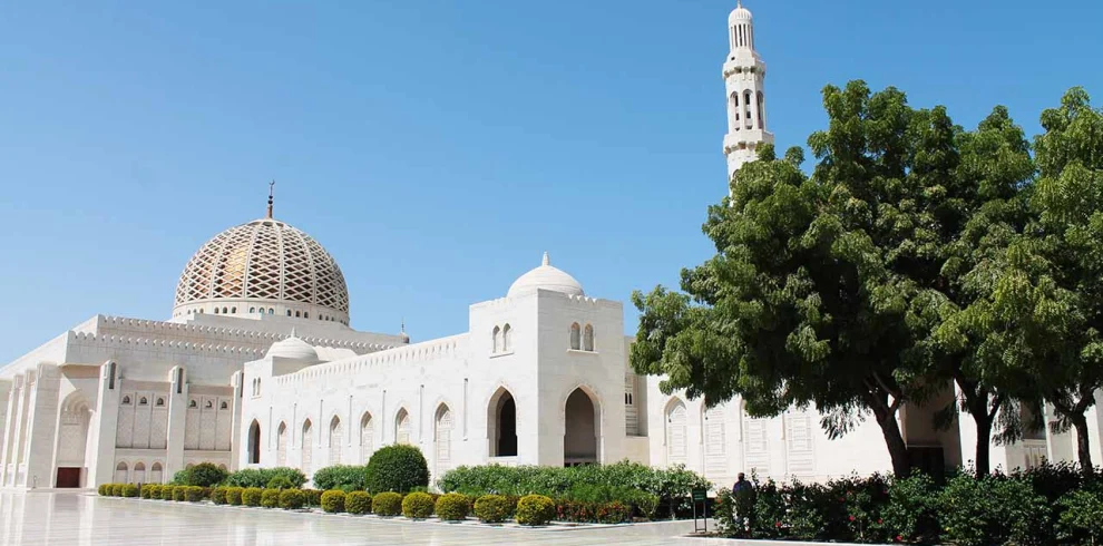 The Sultan Qaboos Grand Mosque with its dome and minaret behind gardens