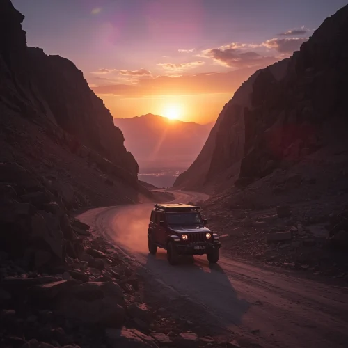 A 4x4 driving through a canyon at sunset