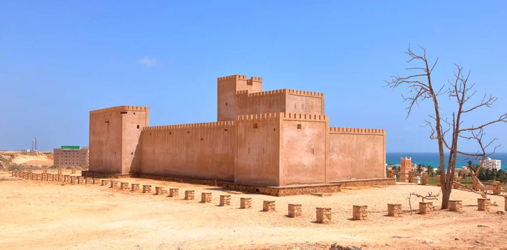 Taqah Castle, a sand-coloured fort under a blue sky