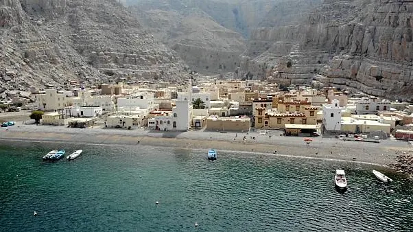 Houses and boats on the shore of Kumzar village, Musandam