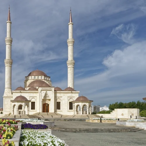 White mosque with two minarets and domed pavilions