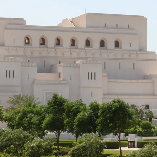 The Royal Opera House Muscat behind trees and lawns