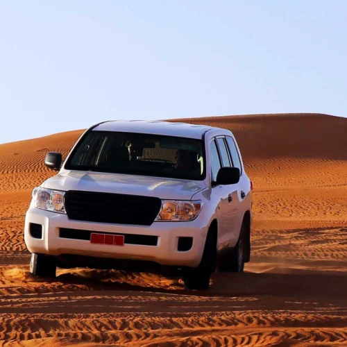 A white 4x4 on a sand dune