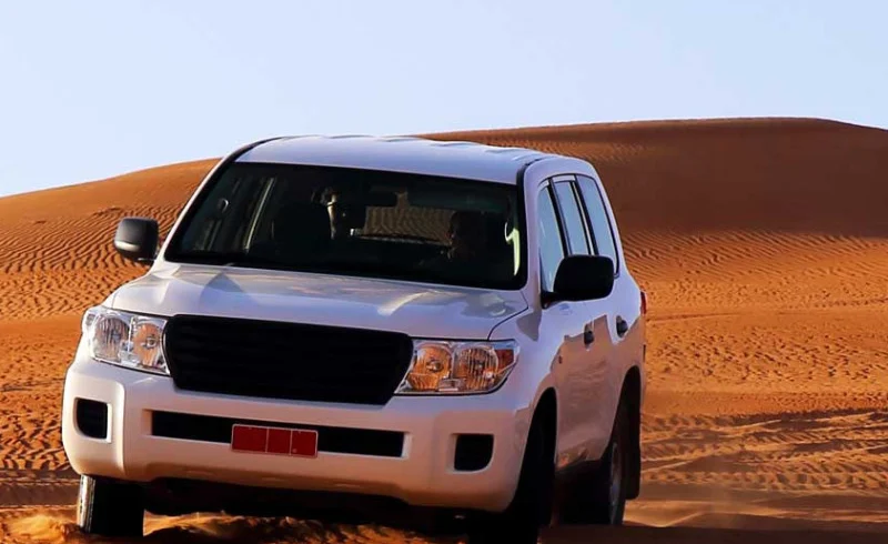 A white 4x4 on a sand dune